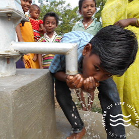 Indian child drinking water from well