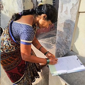 Indian woman writing on tablet - small