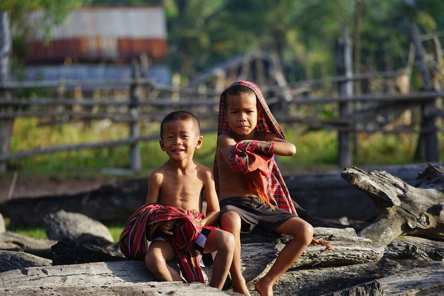 Two young children sitting on log