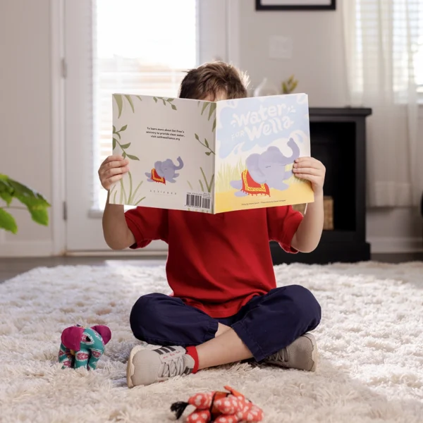 Child reading a Water for Wella book in his room